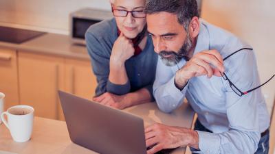 Zwei Menschen sitzen vor dem Computer