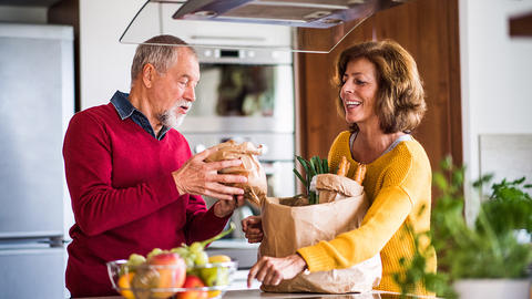 Ehepaar packt in Küche die Einkäufe aus