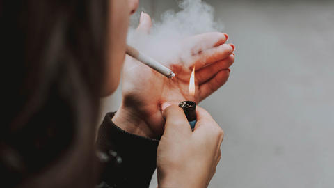 Frau die sich eine Zigarette anzündet