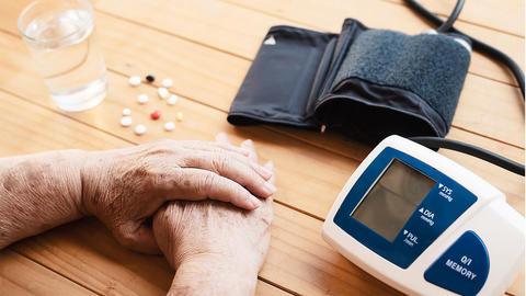 Frau sitzt am Blutdruckmessgerät