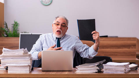 Man hat im Büro stress und fasst sich ans Herz