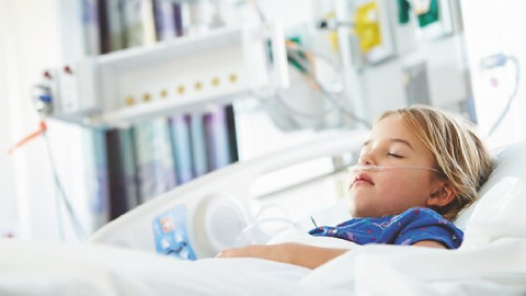  Kind schläft im Krankenhausbett