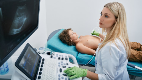 Ärztin führt Herzultraschall bei einem Jungen durch. 